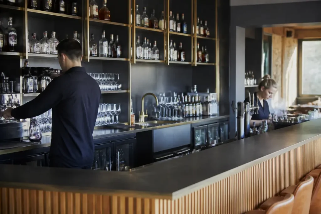 Deux barmans préparent des boissons dans un agencement de bar moderne et élégant