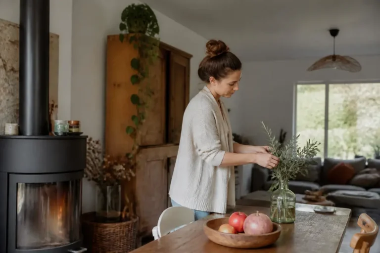 Femme décorant son intérieur avec conseils déco de cosyalamaison.fr et des branches dans un vase