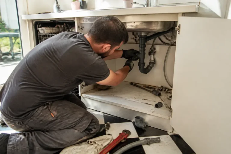 Homme effectuant la maintenance de l'évacuation d'évier et lave-vaisselle pour savoir bricoler efficacement