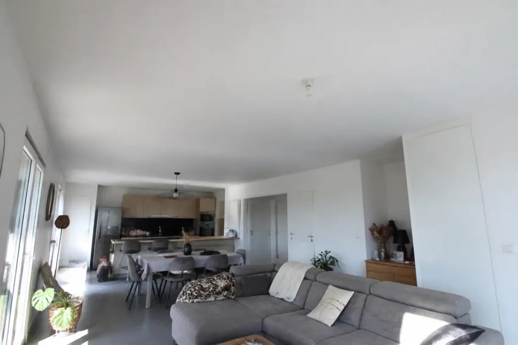 Salon moderne et lumineux avec plafond hauteur standard et cuisine ouverte élégante