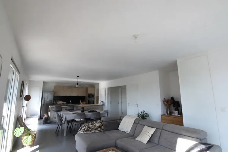Salon moderne et lumineux avec plafond hauteur standard et cuisine ouverte élégante