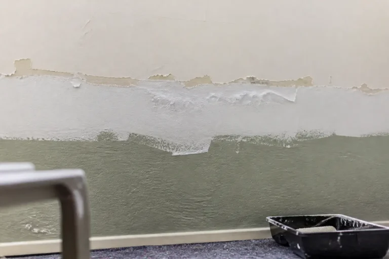 Mur avec 3 couches de peinture, traces visibles et bac à peinture au sol