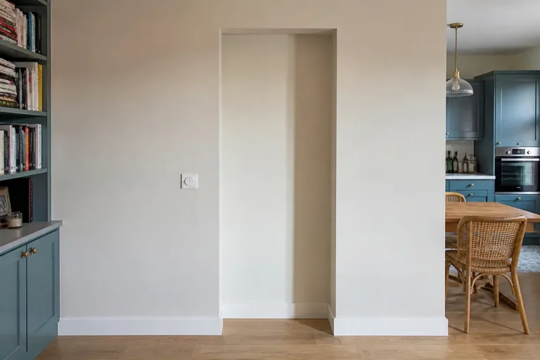 Espace intérieur avec porte condamnée, entouré de meubles modernes et de livres.